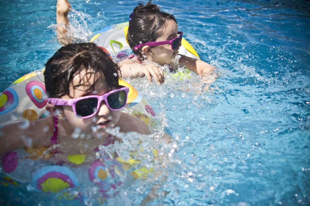Two children with sunglasses in a swimming pool
